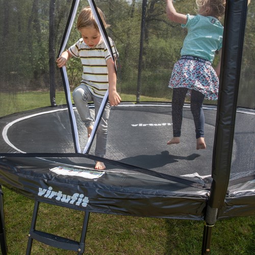 Lifestyle foto van de VirtuFit Premium Trampoline met ladder en een veilige ritsopening voor gemakkelijk in en uitstappen door kinderen.